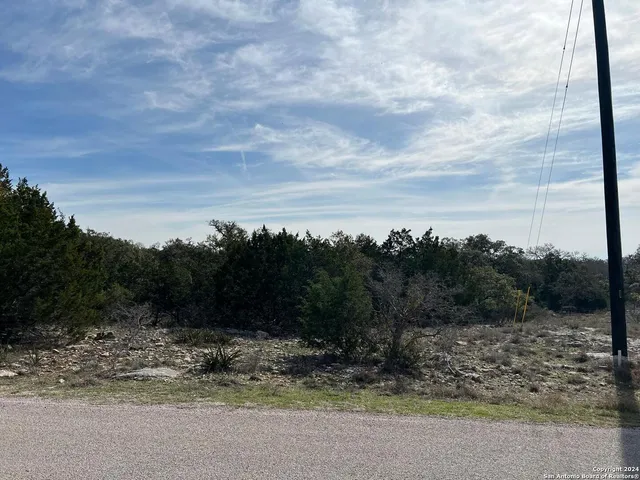 a view of a yard with wooden fence