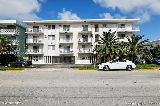 a front view of residential houses with yard and parking
