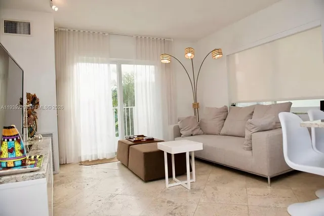 a living room with furniture a bed and a window