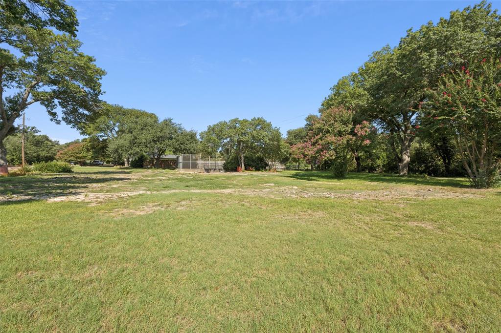 4931 Northaven Road Dallas, TX 75229 - Photo 5 of 8 a view of a green field with trees in the background