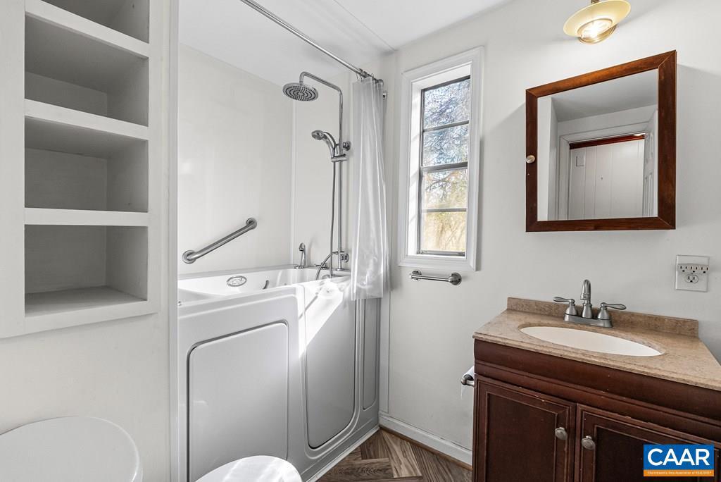 1066 Stevens Cove Road Lovingston, VA 22949 - Photo 13 of 34 a bathroom with a toilet sink and mirror