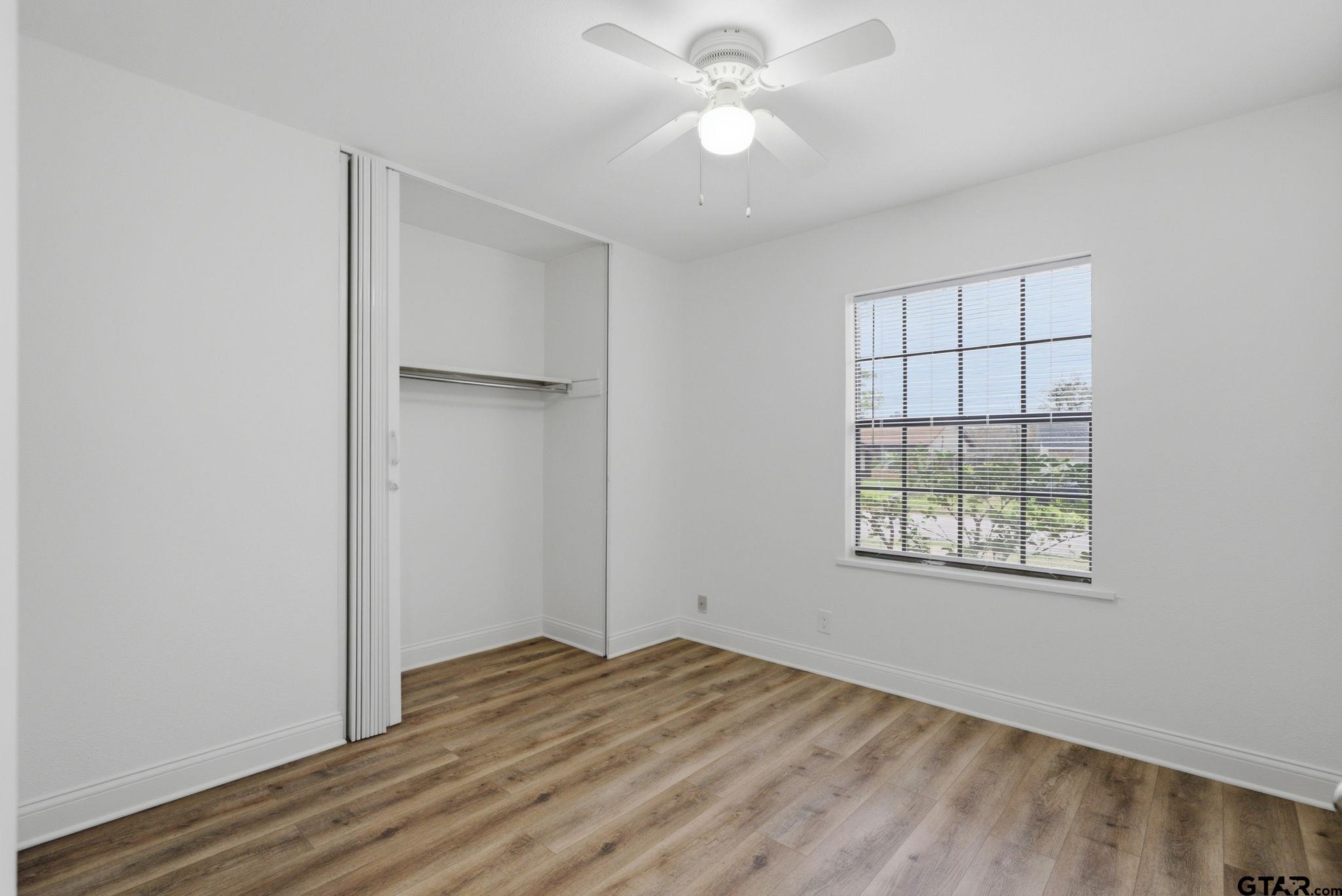 2716 Manilee Lane Tyler, TX 75702 - Photo 12 of 20 an empty room with wooden floor closet and windows