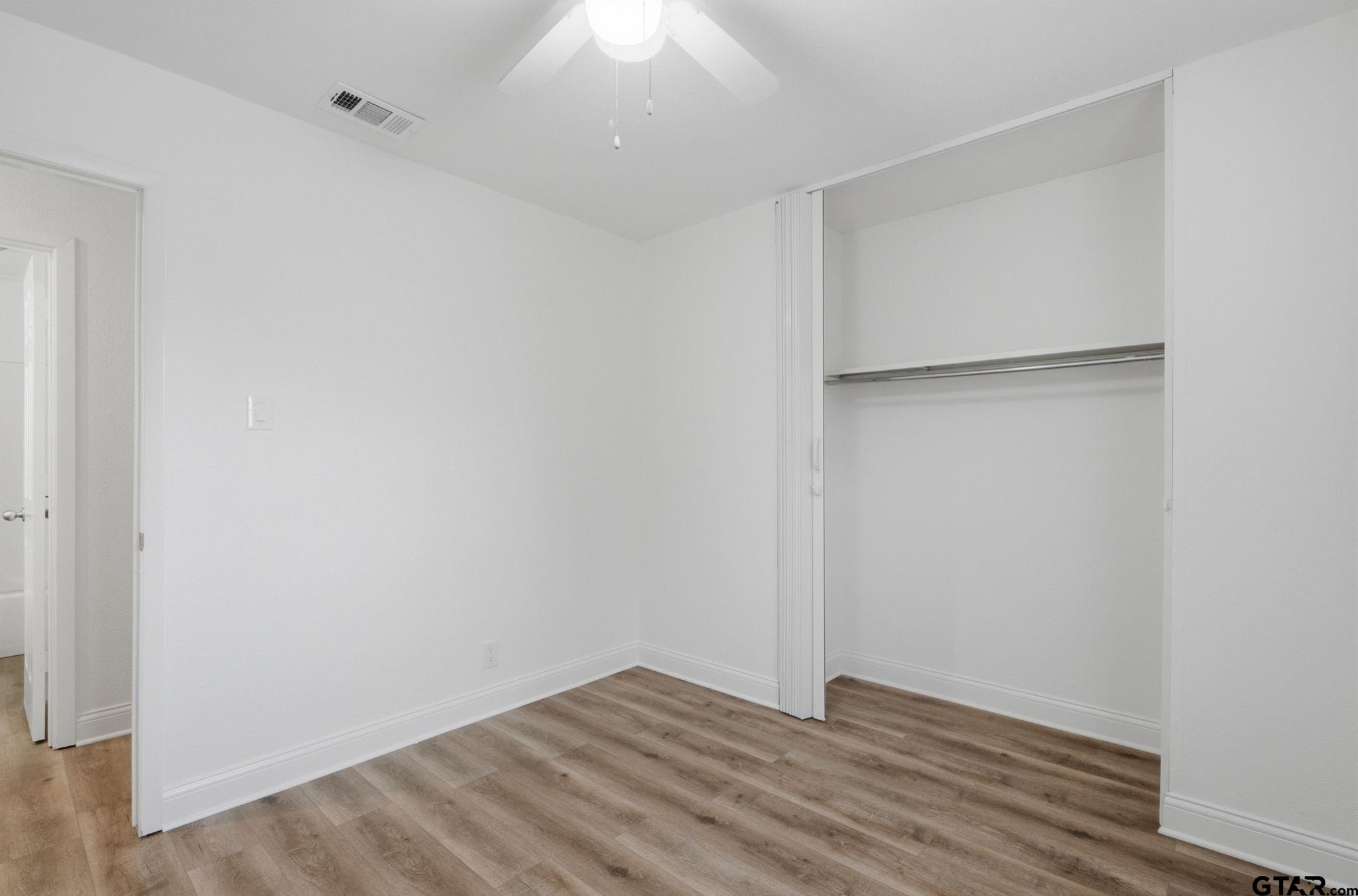 2716 Manilee Lane Tyler, TX 75702 - Photo 13 of 20 a view of an empty room with wooden floor