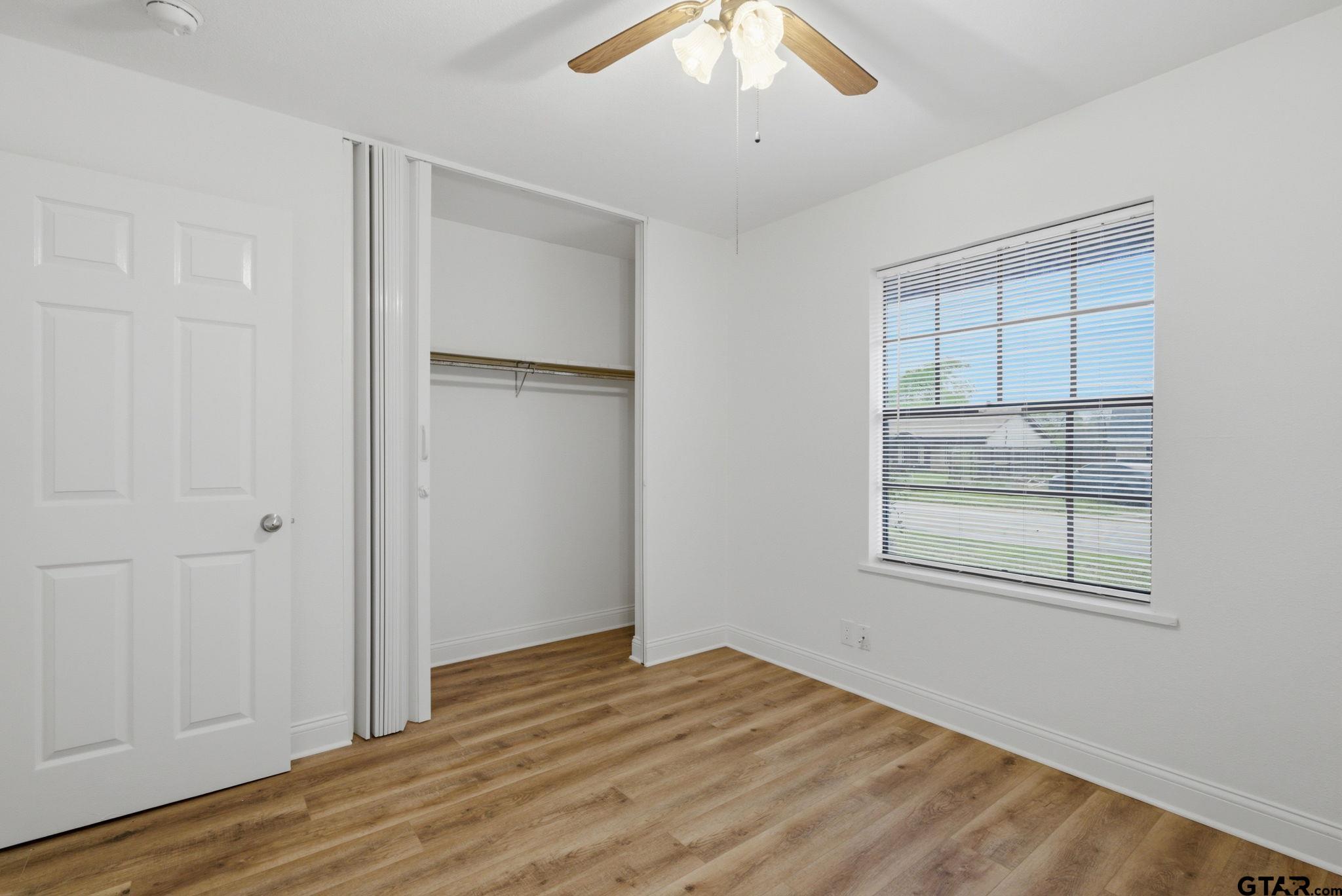 2716 Manilee Lane Tyler, TX 75702 - Photo 15 of 20 an empty room with wooden floor cabinet and windows