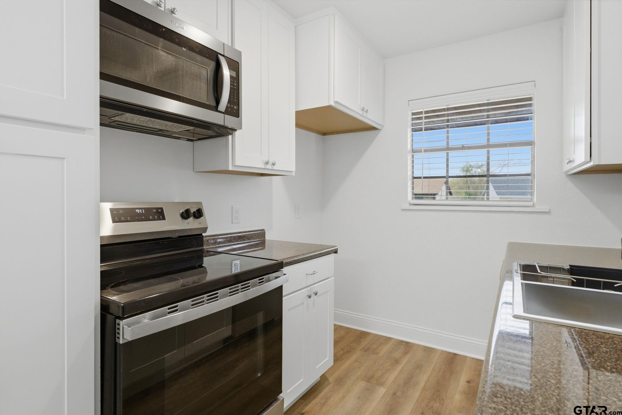 2716 Manilee Lane Tyler, TX 75702 - Photo 7 of 20 a kitchen with wooden cabinets and a stove top oven