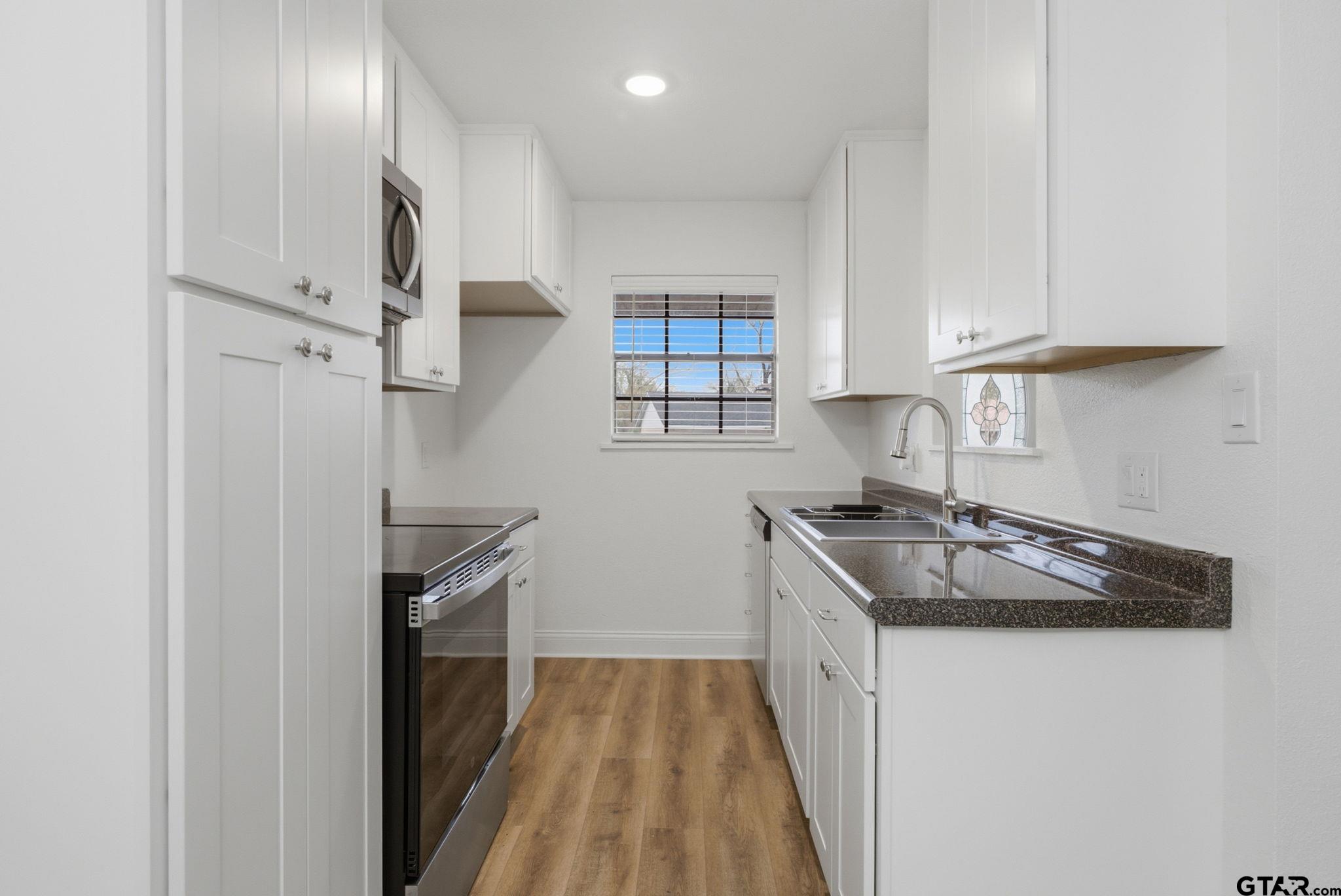 2716 Manilee Lane Tyler, TX 75702 - Photo 8 of 20 a kitchen with stainless steel appliances granite countertop a sink and a stove top oven
