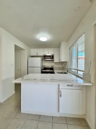 a view of a hallway with wooden floor and a bathroom