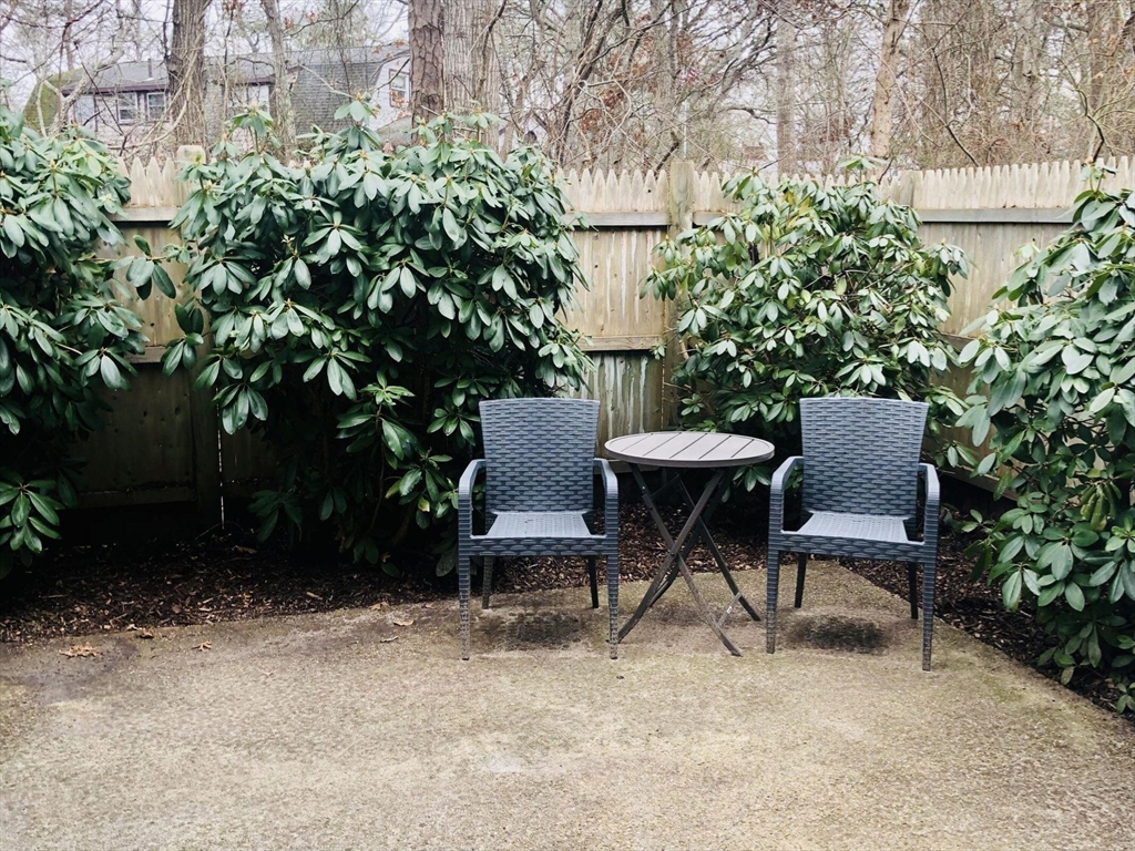 135 West Main Street, Unit 26 Barnstable, MA 02601 - Photo 11 of 11 a view of a chairs and table in a backyard