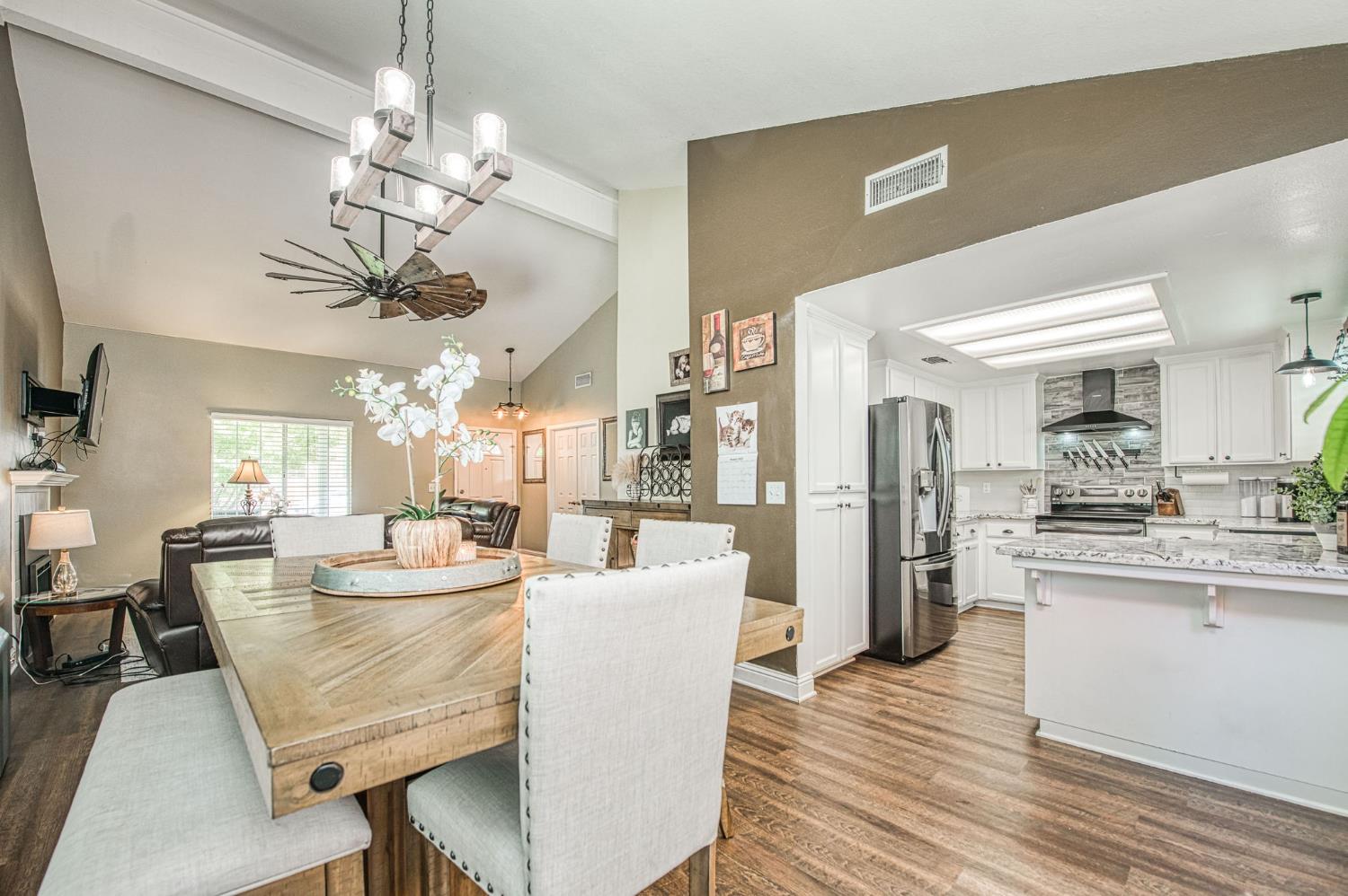 980 North Adler Avenue Clovis, CA 93611 - Photo 11 of 42 a view of a dining room and livingroom with furniture wooden floor a chandelier