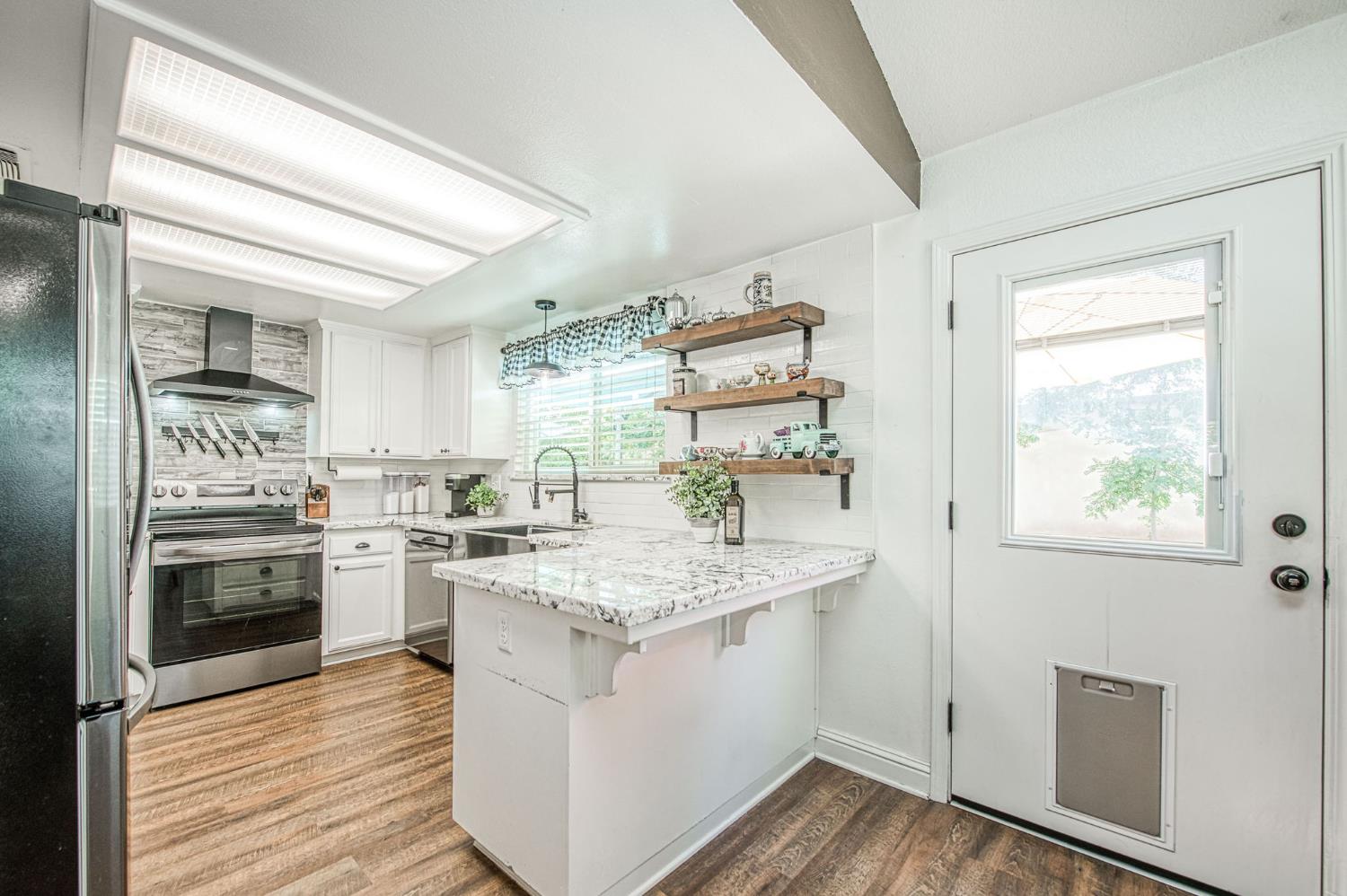 980 North Adler Avenue Clovis, CA 93611 - Photo 13 of 42 a kitchen with stainless steel appliances granite countertop a stove and a sink