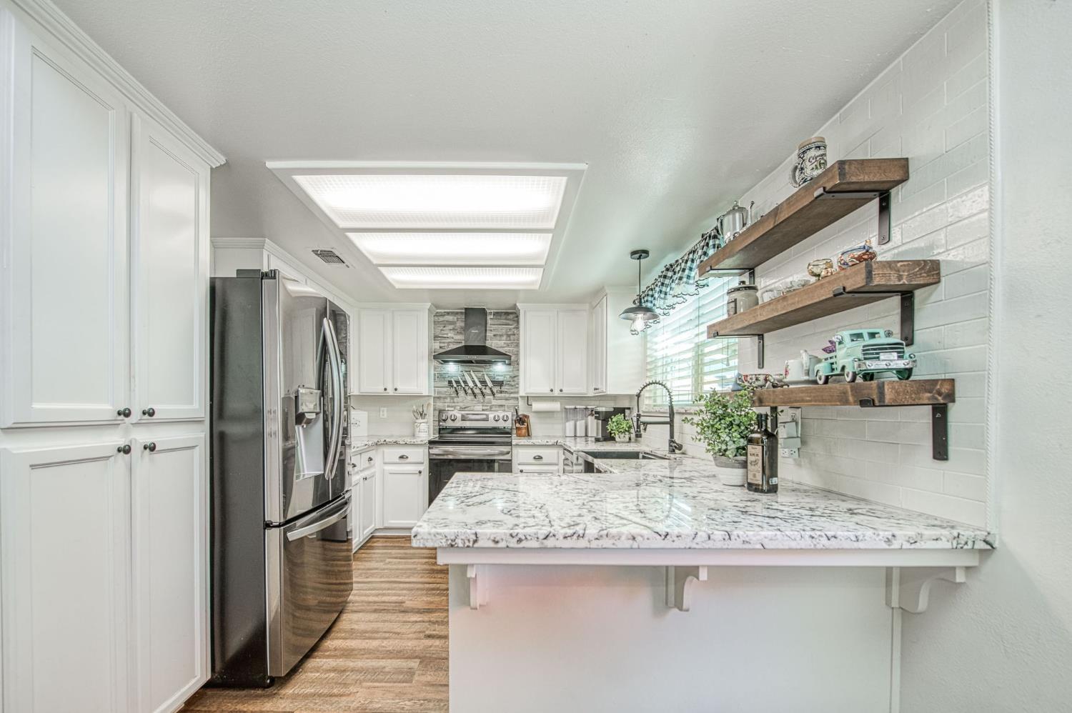 980 North Adler Avenue Clovis, CA 93611 - Photo 14 of 42 a kitchen with stainless steel appliances granite countertop a sink and refrigerator