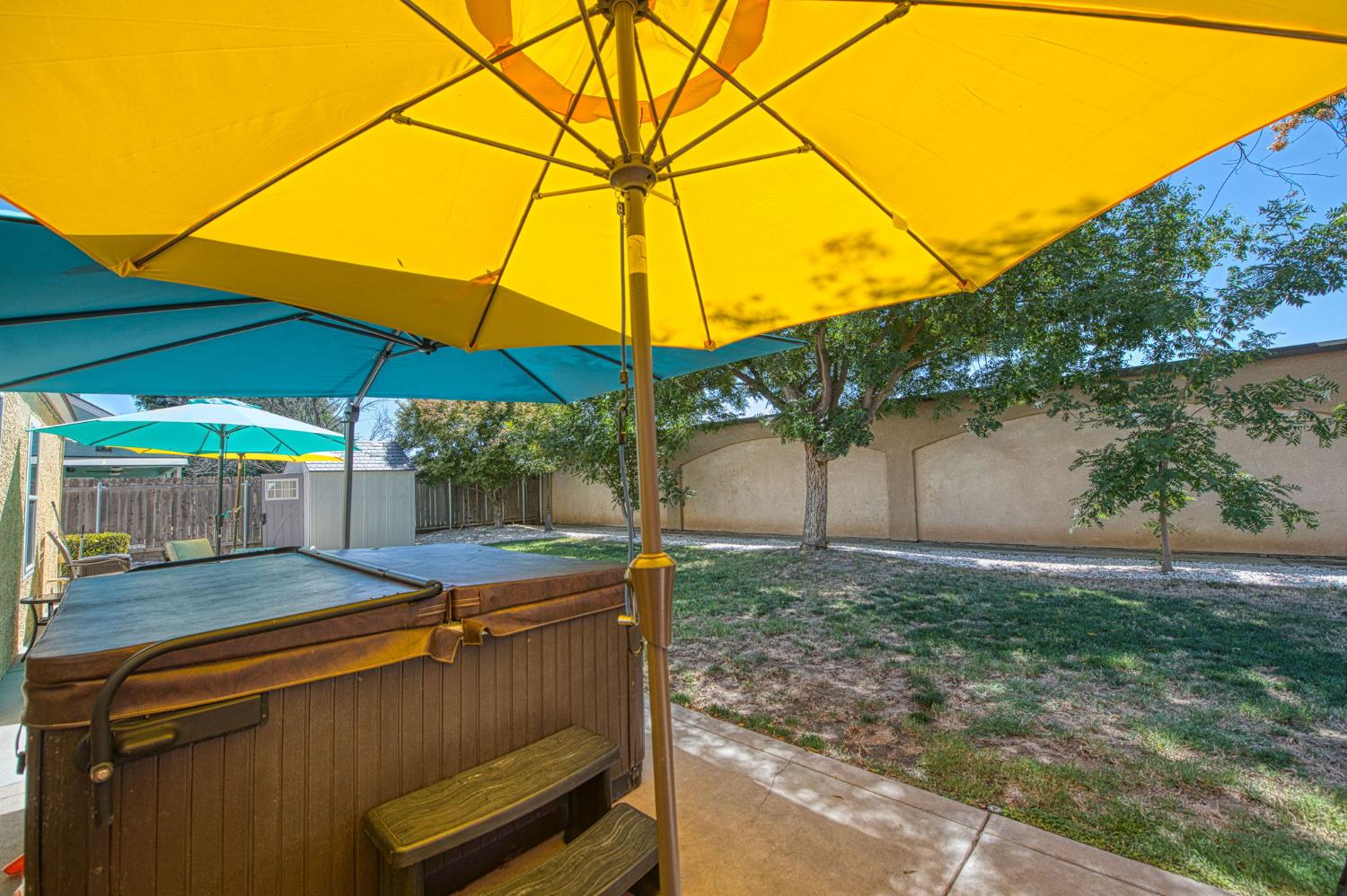 980 North Adler Avenue Clovis, CA 93611 - Photo 31 of 42 a backyard of a house with table and chairs under an umbrella