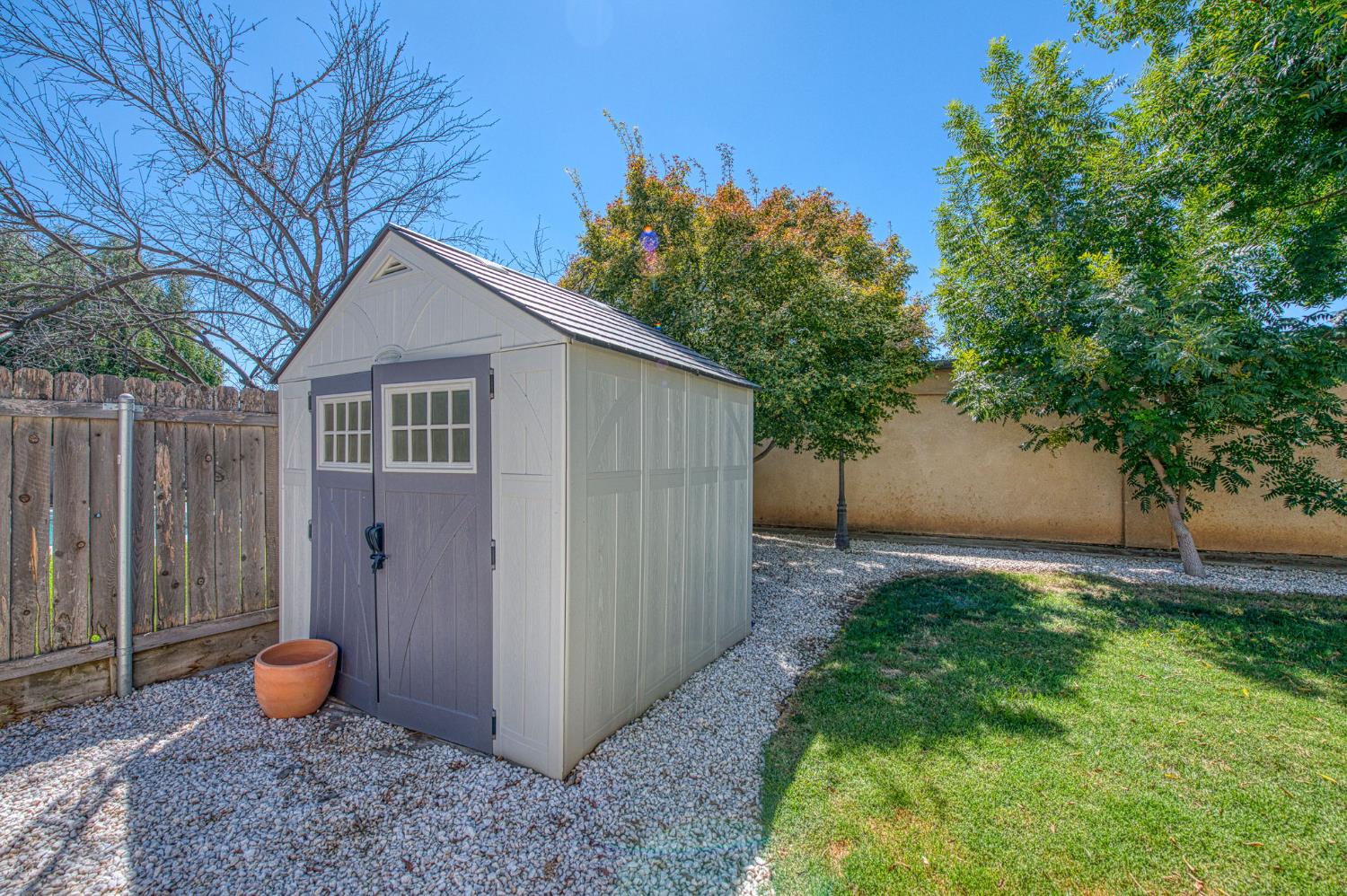 980 North Adler Avenue Clovis, CA 93611 - Photo 34 of 42 a backyard of a house with potted plants and large tree