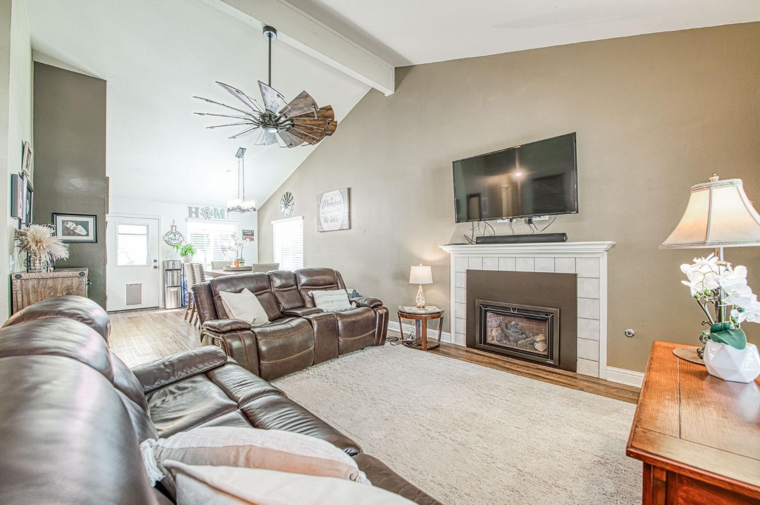 980 North Adler Avenue Clovis, CA 93611 - Photo 6 of 42 a living room with furniture a flat screen tv and a fireplace