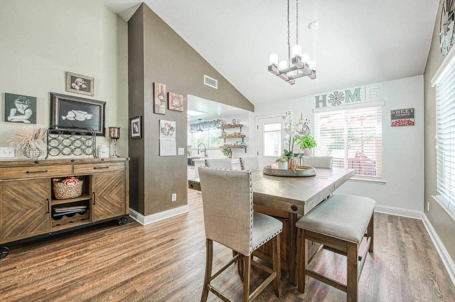 980 North Adler Avenue Clovis, CA 93611 - Photo 9 of 42 a dining room with furniture a chandelier and wooden floor