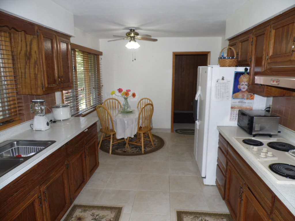 3305 Spring Creek Road Rockford, IL 61107 - Photo 3 of 20 a kitchen with refrigerator a stove a sink and cabinets