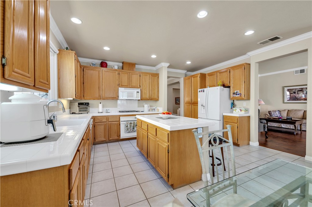 37678 Newcastle Road Murrieta, CA 92563 - Photo 18 of 44 a kitchen with stainless steel appliances granite countertop a refrigerator a stove a sink a dining table and chairs with wooden floor
