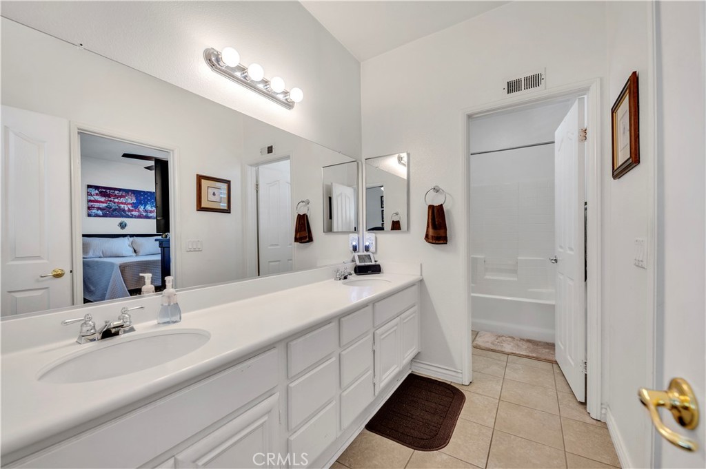 37678 Newcastle Road Murrieta, CA 92563 - Photo 30 of 44 a spacious bathroom with a double vanity sink a mirror and a bathtub