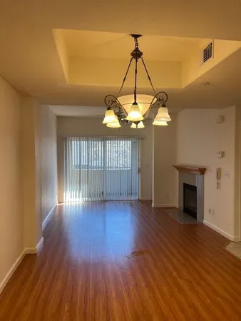 a view of a livingroom with wooden floor a chandelier