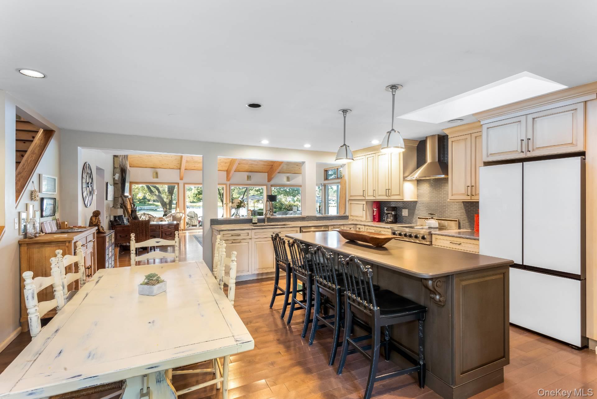 3693 Pine Neck Road Southold, NY 11971 - Photo 7 of 16 Kitchen with freestanding refrigerator, tasteful backsplash, light wood-type flooring, a kitchen island, and pendant lighting