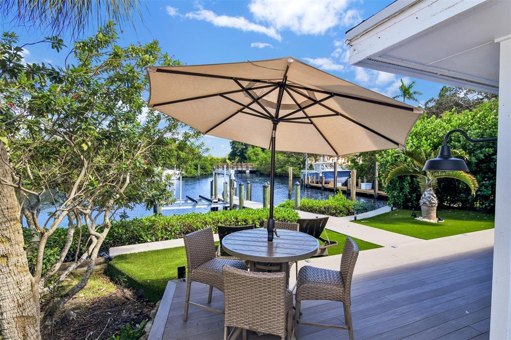 17026 Bay Street Jupiter, FL 33477 - Photo 33 of 77 a view of a table and chairs under an umbrella in backyard