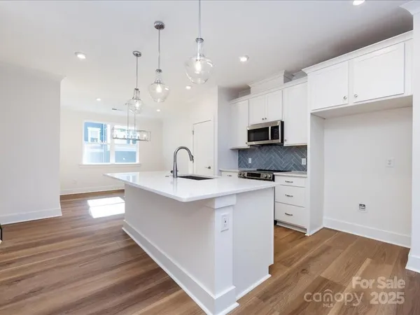 a kitchen with kitchen island a sink stainless steel appliances and cabinets