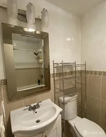 a bathroom with a toilet a sink and mirror