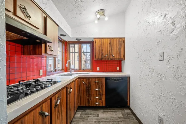 a kitchen with stainless steel appliances a stove and a sink