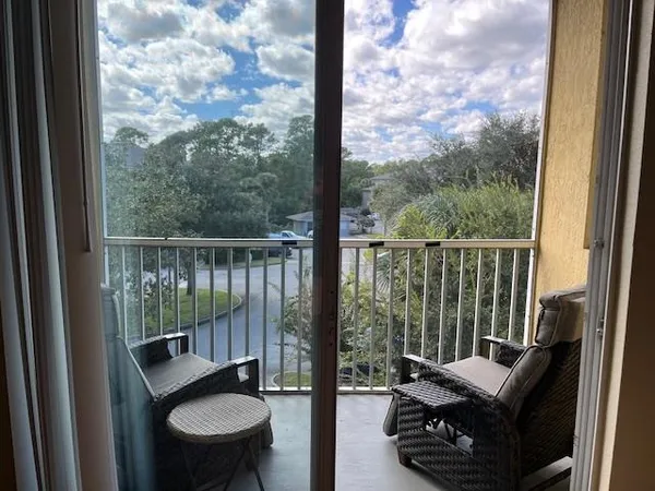 a balcony view with a couple of couches and a potted plant