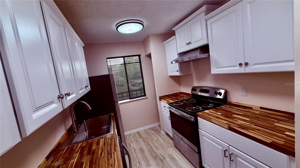 6519 West Newberry Road, Unit 206 Gainesville, FL 32605 - Photo 6 of 14 a kitchen with granite countertop a stove and a refrigerator