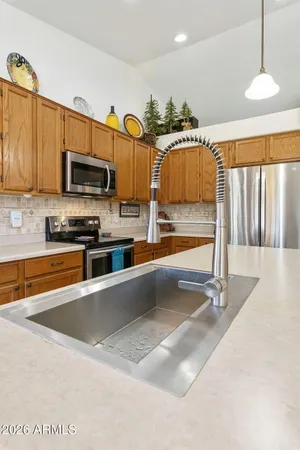 a kitchen with stainless steel appliances granite countertop a sink a stove and a refrigerator