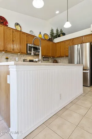 a kitchen with stainless steel appliances kitchen island granite countertop a refrigerator and a stove top oven