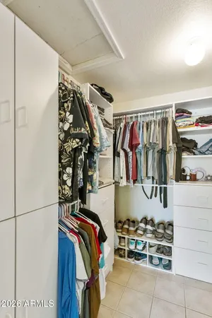 a view of walk in closet with clothes and shoes