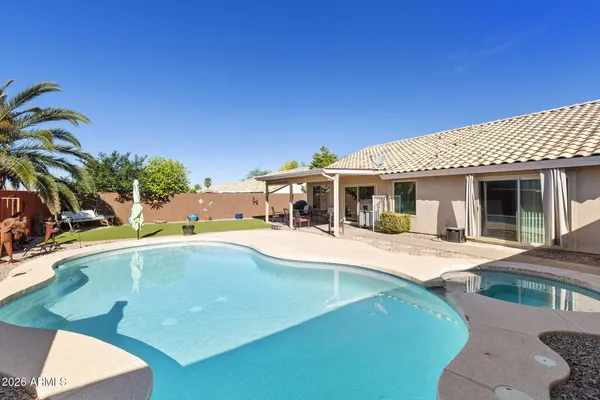 a view of a house with swimming pool and sitting area