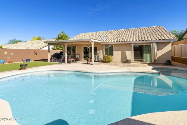 a view of a house with pool and chairs