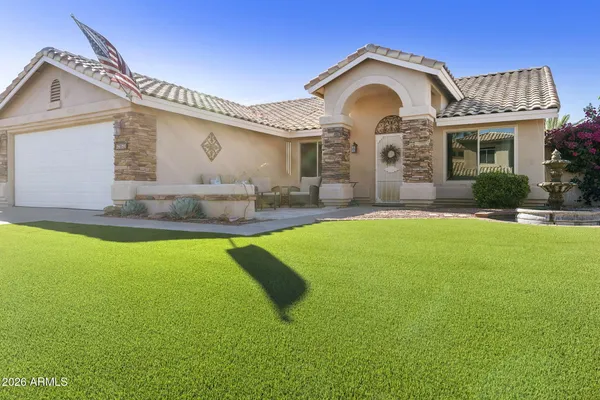 a front view of a house with a garden and yard