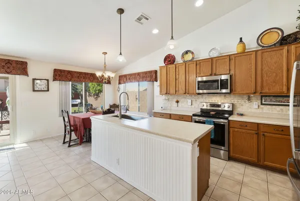 a kitchen with a sink a counter top space appliances and cabinets