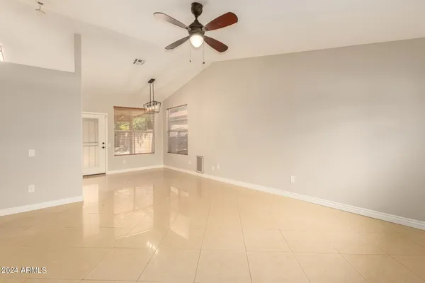 an empty room with windows and fan