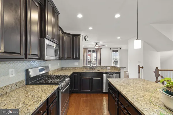 a kitchen with stainless steel appliances granite countertop sink stove top oven and cabinets