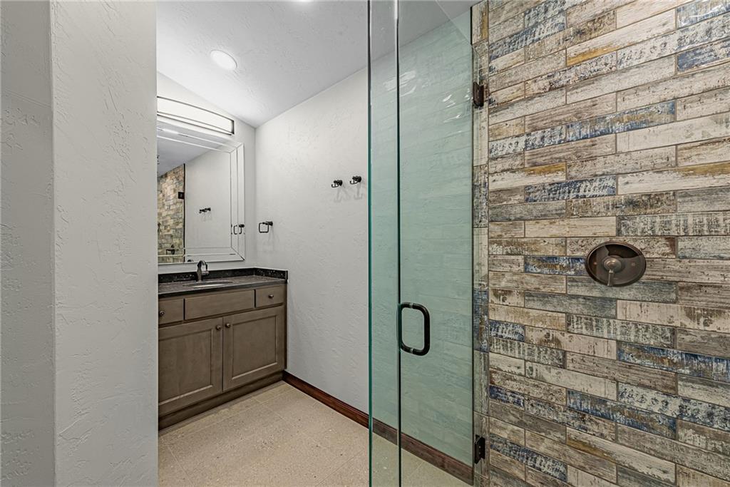 539 Lake Road Addison, PA 15411 - Photo 26 of 43 a bathroom with a granite countertop sink a mirror and shower