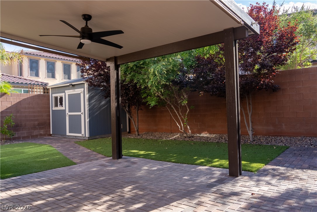 11045 Elk Sands Road Las Vegas, NV 89179 - Photo 34 of 67 A shaded paver patio overlooks the manicured lawn, storage shed, and surrounding privacy walls.