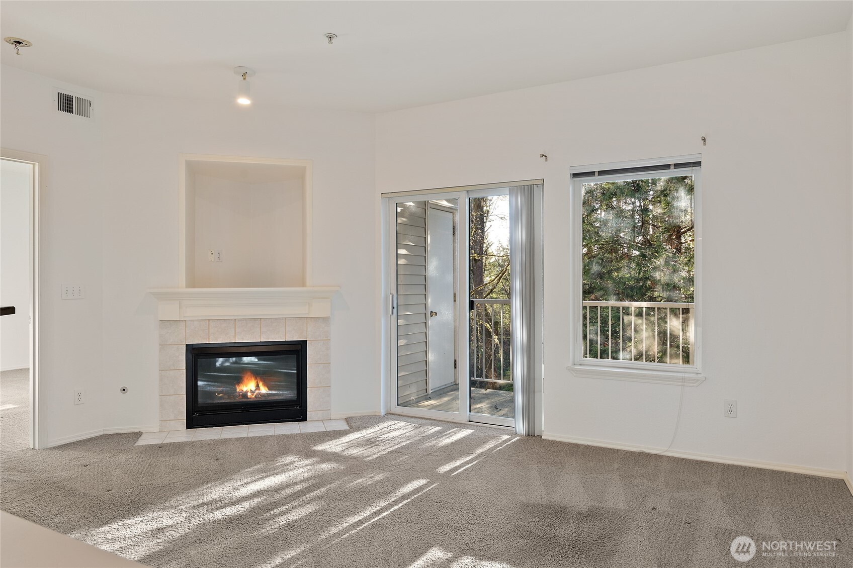 12122 Northeast 171st Place, Unit D201 Bothell, WA 98011 - Photo 17 of 33 a view of an empty room with a fireplace and a window