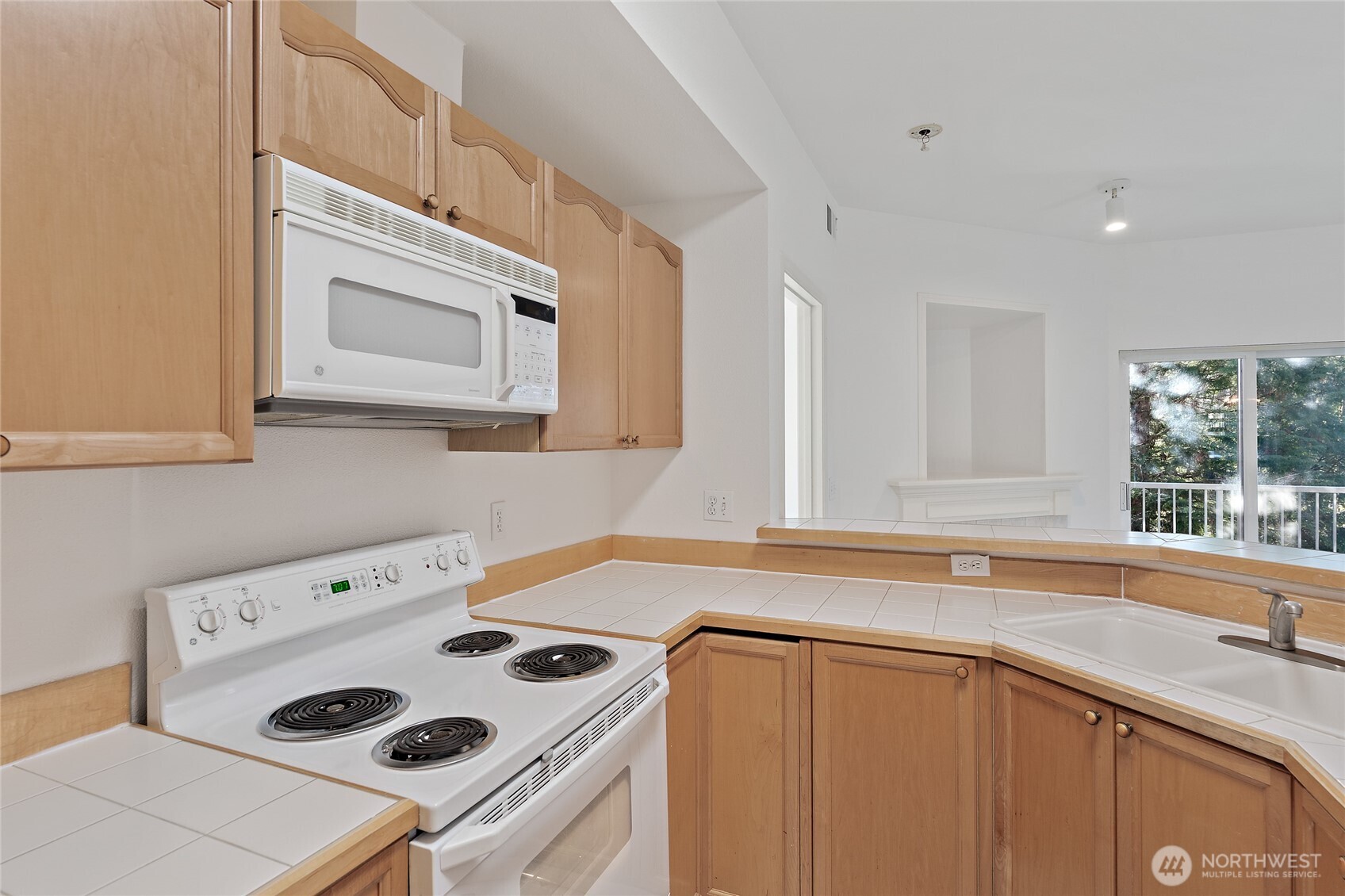12122 Northeast 171st Place, Unit D201 Bothell, WA 98011 - Photo 7 of 33 a kitchen with a sink a stove and cabinets