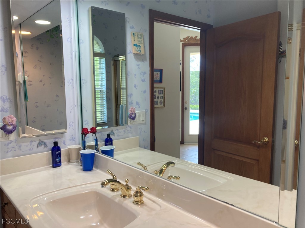 5619 Marina Road Bokeelia, FL 33922 - Photo 13 of 18 a bathroom with a tub sink and mirror