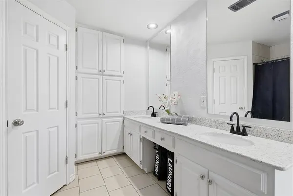 a bathroom with a double vanity sink a mirror and a bathtub