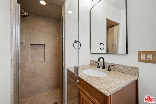 a bathroom with a granite countertop sink and a mirror