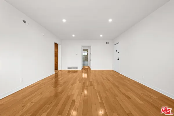 a view of empty room with wooden floor