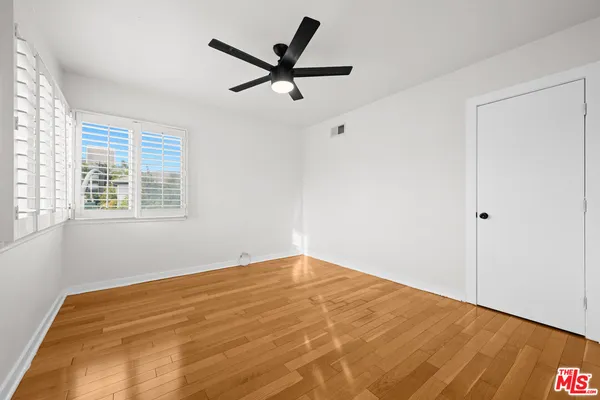 a view of a big room with wooden floor and windows