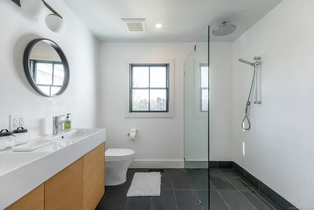 a bathroom with a granite countertop sink toilet and shower