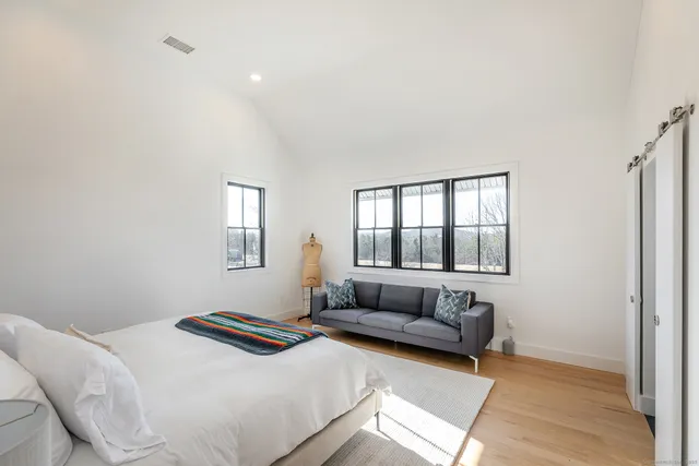 a bedroom with a bed couch and window